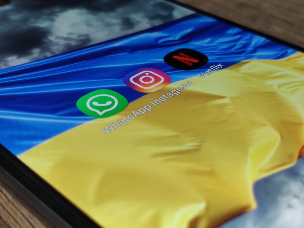 Logos de las apps WhatsApp, Instagram y Netflix sobre la bandera de Ucrania