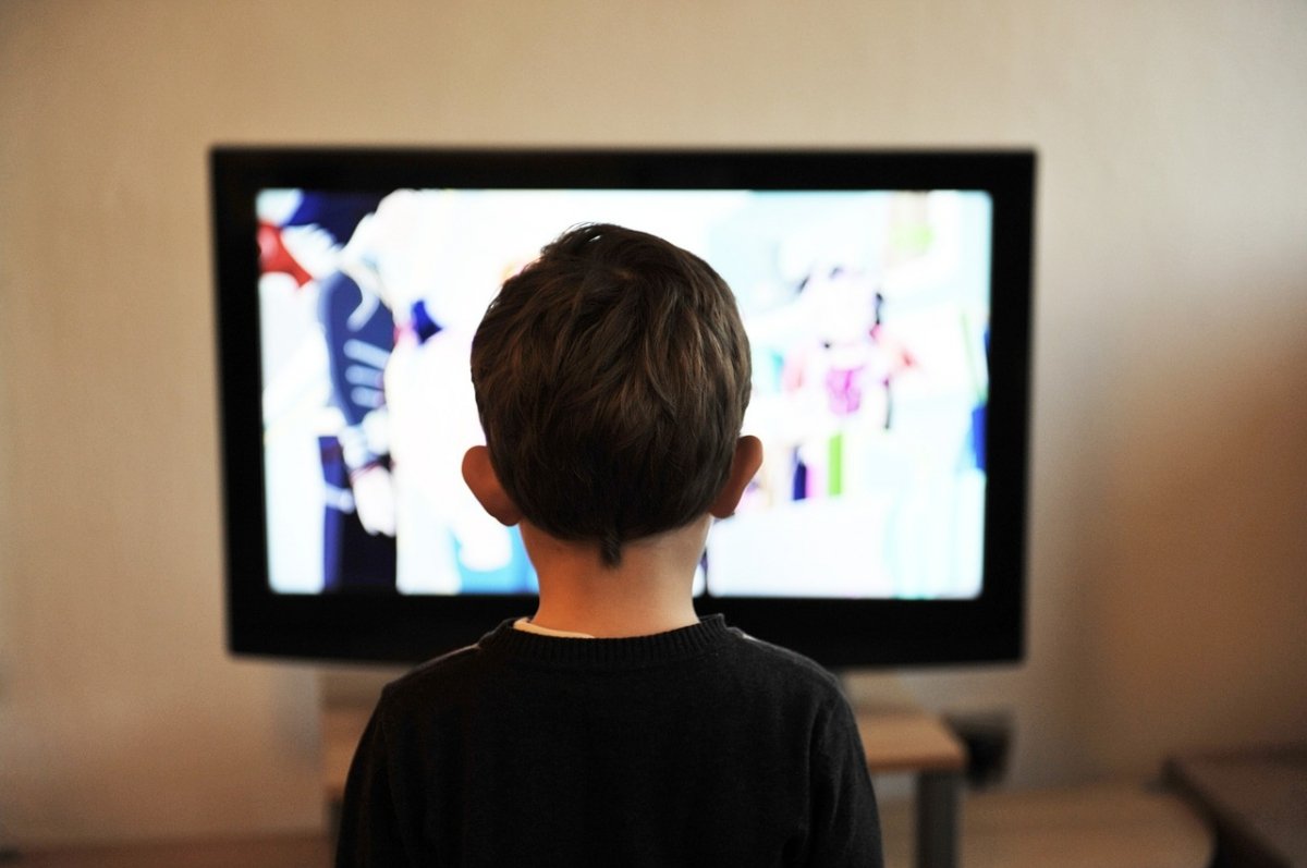 Un niño frente a un televisor